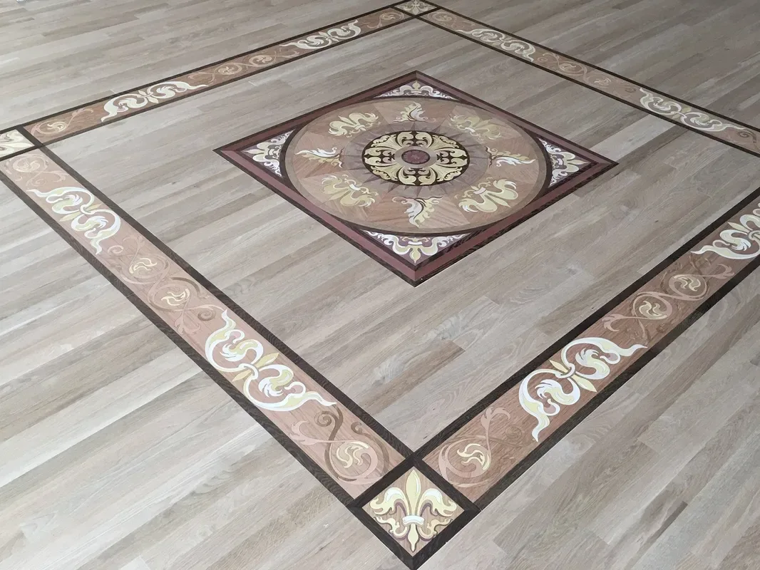 Hand-set parquet field with an ornate inlaid border