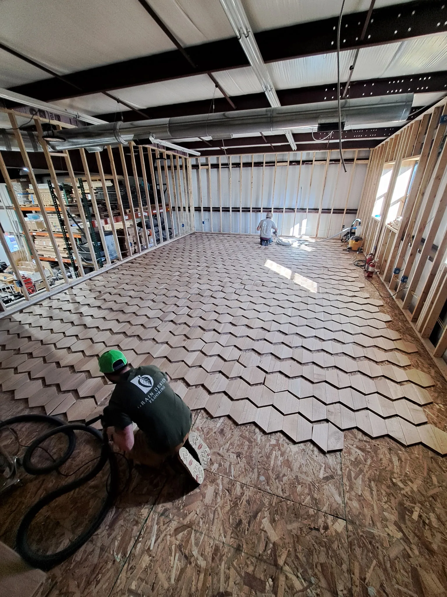 Grain Design crew hand-laying a geometric hardwood floor in a commercial build-out