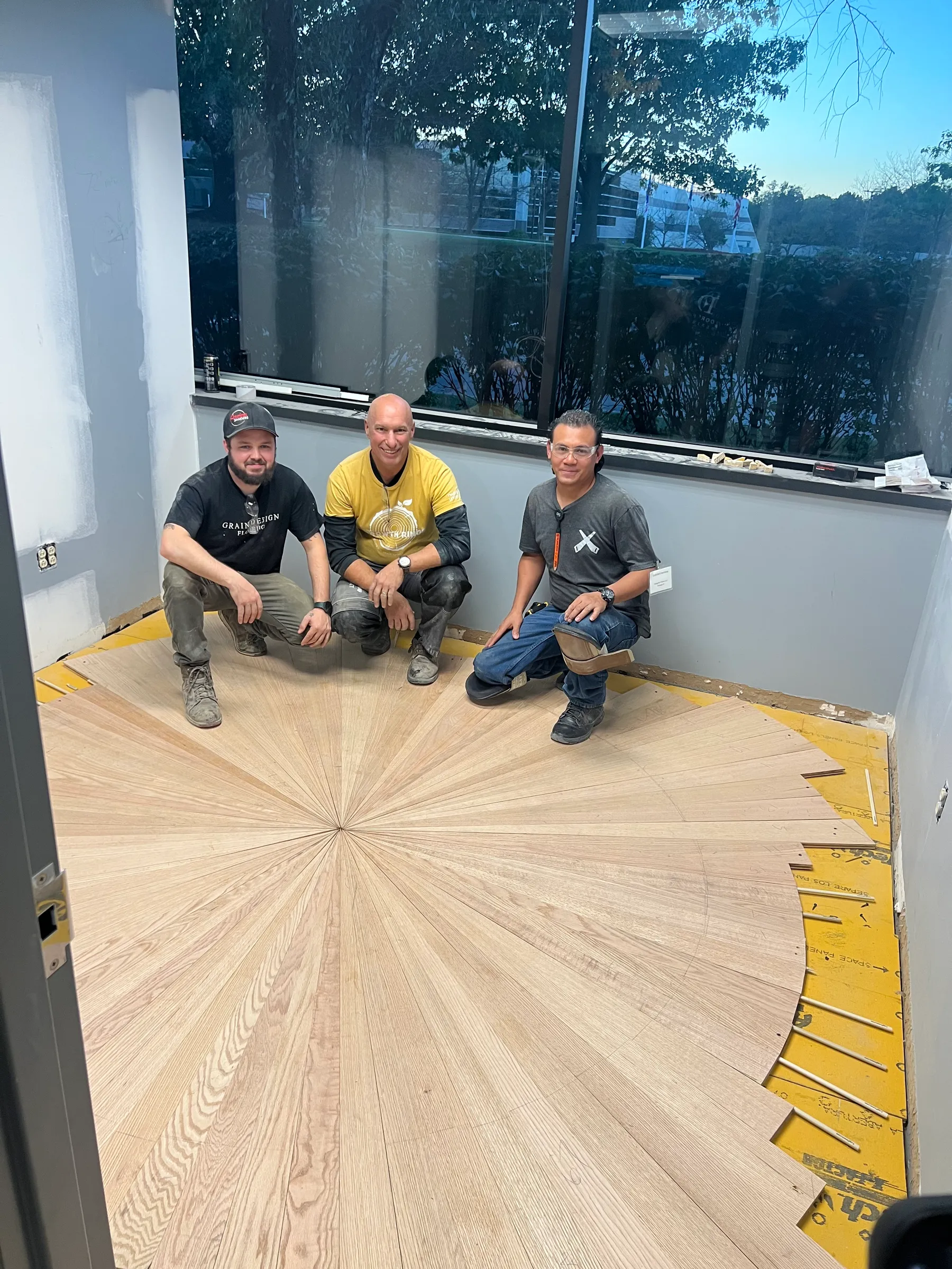 The Grain Design crew with a hand-laid radial sunburst hardwood floor