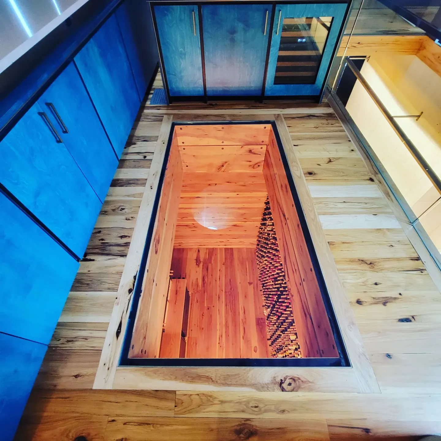Hardwood kitchen floor with a glass panel over a custom wine cellar below